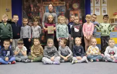 ABSOLWENTKA JULIA GŁOWACKA POZUJE Z KRASNOLUDKAMI DO PAMIĄTKOWEGO ZDJĘCIA.