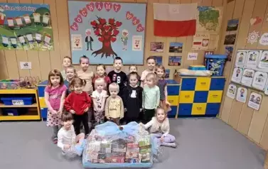 Reprezentacja grup przedszkolnych pozuje do zdjęcia z zebranymi herbatami 