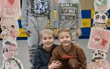 Dzieci pozują do zdjęcia w walentynkowej fotobudce