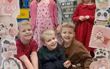 Dzieci pozują do zdjęcia w walentynkowej fotobudce