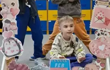 Dzieci pozują do zdjęcia w walentynkowej fotobudce
