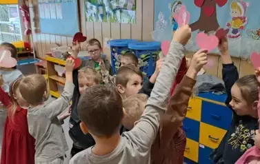 Dzieci biorą udział w zabawie muzyczno-ruchowej o tematyce walentynkowej