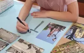 DZIEWCZYNKA SIEDZI PRZY STOLIKU I MALUJE