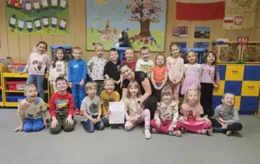 Dzieci pozują z prowadzącą warsztaty do zdjęcia