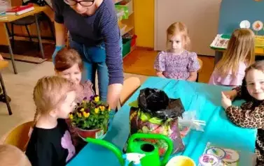 Dzieci wąchają zasadzone kwiaty
