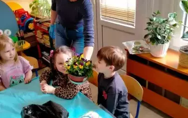 Dzieci wąchają zasadzone kwiaty