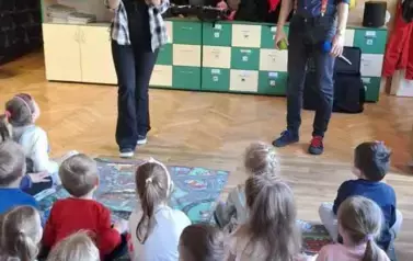 Dzieci słuchają prowadzących opowiadających o instrumentach, kt&oacute;re przynieśli