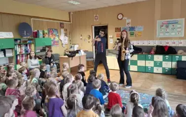 Dzieci słuchają koncertu prowadzących audycje muzyczne