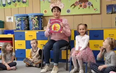Babcia Gabrysi czyta dzieciom książkę 