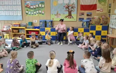Dzieci słuchają bajki czytanej przez babcię Gabrysi 
