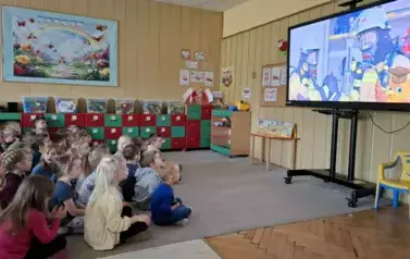 Dzieci oglądają film edukacyjny o strażakach 