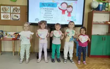 Dziewczynki z grupy Biedronek pozują do zdjęcia z pracami plastycznymi
