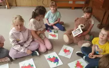 Dzieci z grupy Słoneczek pozują do zdjęcia ze swoimi pracami plastycznymi