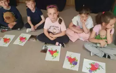 Dzieci z grupy Słoneczek pozują do zdjęcia ze swoimi pracami plastycznymi