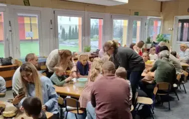 Dzieci i rodzice przygotowują razem deser