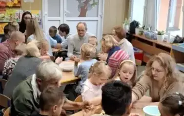 Dzieci i rodzice przygotowują razem deser