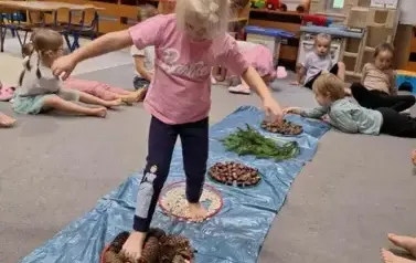 Dziecko przechodzi przez sensoryczną ścieżkę 