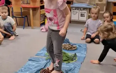 Dziecko przechodzi przez sensoryczną ścieżkę 