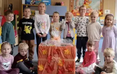 Reprezentacja dzieci z wszystkich grup przedszkolnych pozuje do zdjęcia z zebranymi herbatkami