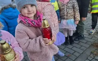 Dzieci stawiają znicze na grobach poległych żołnierzy