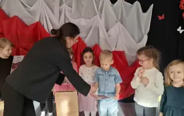 Prowadząca wręcza dyplom i nagrody
