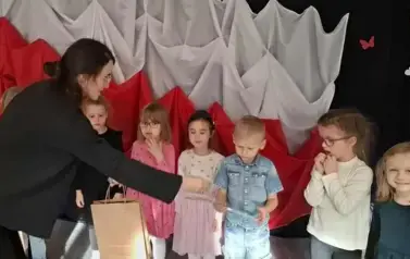 Prowadząca wręcza dyplom i nagrody