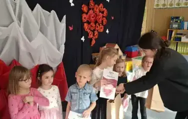Prowadząca wręcza dyplom i nagrody
