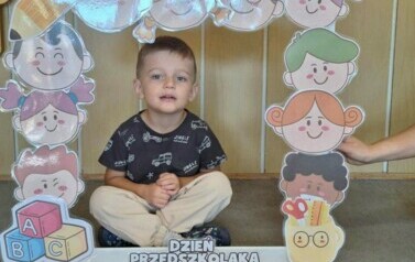 chłopiec z grupy motylk&oacute;w pozuje w fotobudce
