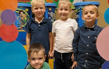 Grupa chłopc&oacute;w pozuje w kropkowej foto budce 