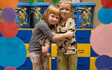 Dziewczynka i chłopiec z grupy zajączk&oacute;w pozują do zdjęcia w kropkowej foto budce