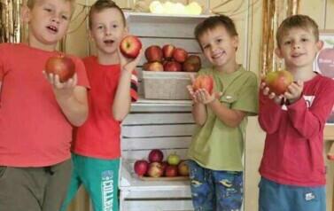 chłopcy z grupy krasnali pozują przy jabłkowej fotobudce