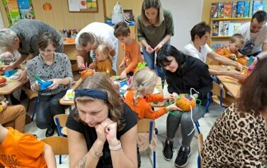 Dzieci z rodzicami ozdabiają dynie 