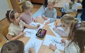Dzieci przy stoliku tworzą swoje prace plastyczne