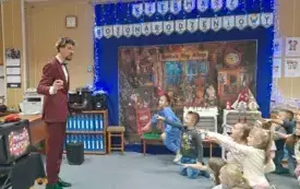 Dzieci wskazują kurze jajko trzymane przez magika