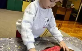 Chłopiec rozwałkowuje ciasto na pierniczki