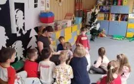 Absolwentka czyta bajkę w grupie krasnali