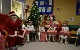 Dzieci z grupy Biedronek otrzymują prezenty od Mikołaja