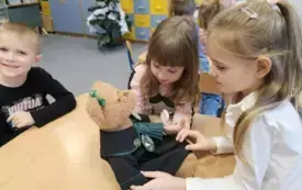Dzieci przyglądają się misiowi