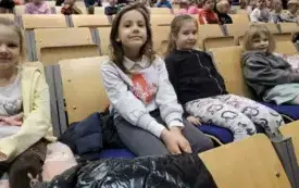 DZIEWCZYNKI W OCZEKIWANIU NA SPEKTAKL TEATRALNY POZUJĄ DO ZDJĘCIA.