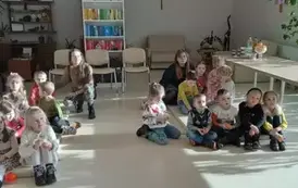 Dzieci siedzą na materacach z Paniami w hospicjum 
