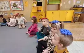 Dzieci siedzą z klocami na głowie