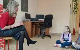 Dzieci siedzą i słuchają Pani bibliotekarki 