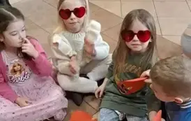 Dzieci w czerwonych okularach pozują do zdjęcia 
