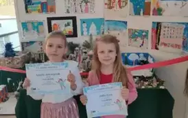 Dziewczynki pozują z dyplomami do zdjęcia 