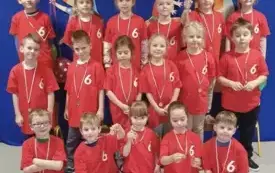 MALI SPORTOWCY Z GRUPY SŁONECZKA POZUJĄ Z MEDALAMI I PUCHAREM