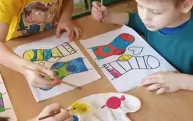 CHŁOPCY Z GRUPY SŁONECZKA MALUJĄ FARBAMI SZABLON SKARPETEK