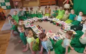 ZDJĘCIE GRUPOWE SŁONECZEK W KOLOROWYCH SKARPETKACH I TEMATYCZNYMI PRACAMI PLASTYCZNYMI
