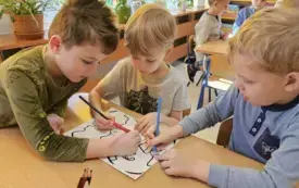 ZAJĄCZKI MALUJĄ KREDKAMI KOLOROWANKĘ TEMATYCZNĄ