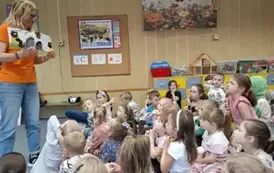 Pani Barbara czyta dzieciom książkę i prezentuje ilustracje
