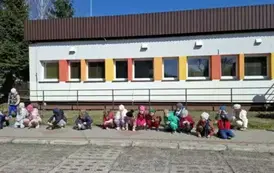 Dzieci pozują do zdjęć z zasadzonymi na terenie plac&oacute;wki drzewami i krzewami